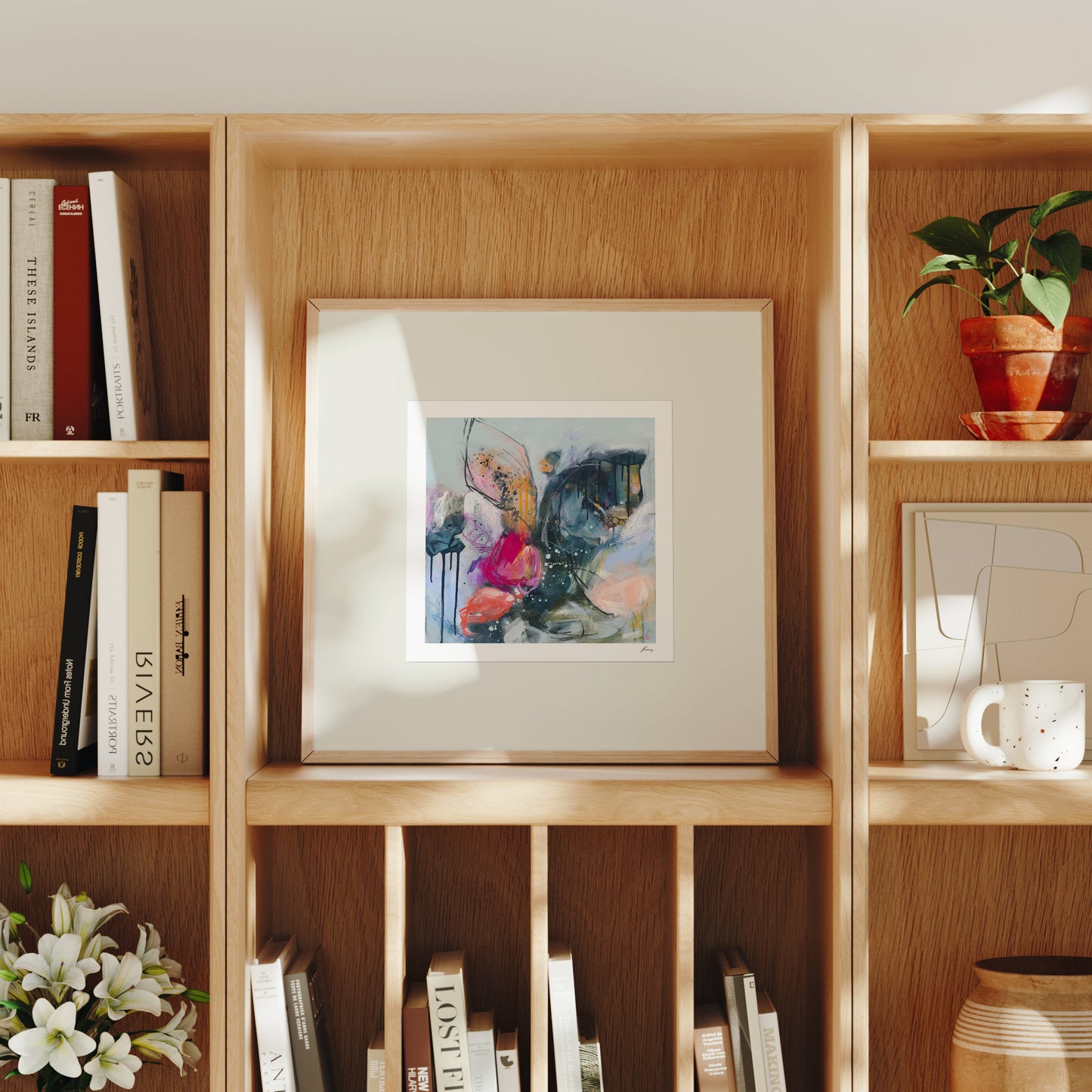 Wooden bookshelf with books, a framed abstract painting, and decorative items.