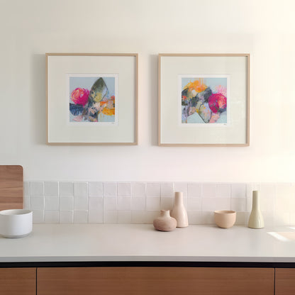 Modern kitchen with wooden cabinets, white countertop, and framed artwork on the wall.