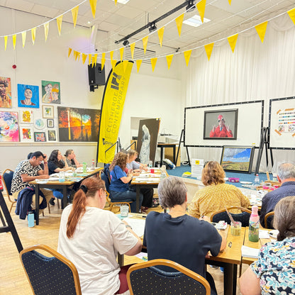 People sitting at tables in a modern cafe with yellow decor elements.